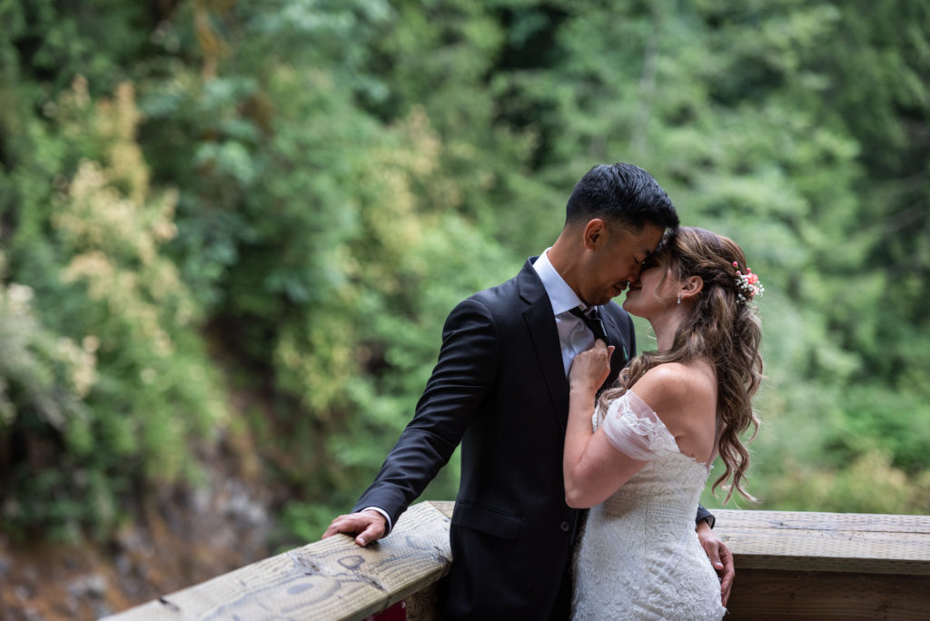 Bride and groom embracing with trees in the background