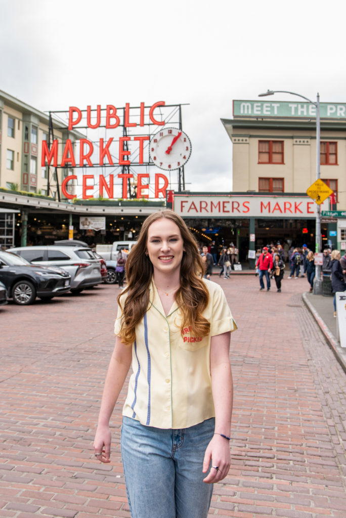 high school senior walking in the street at Pike Place Market in Seattle