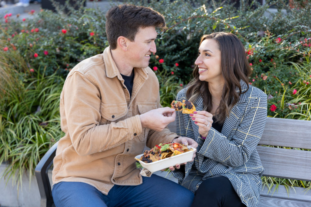 male and female couple eating nachos